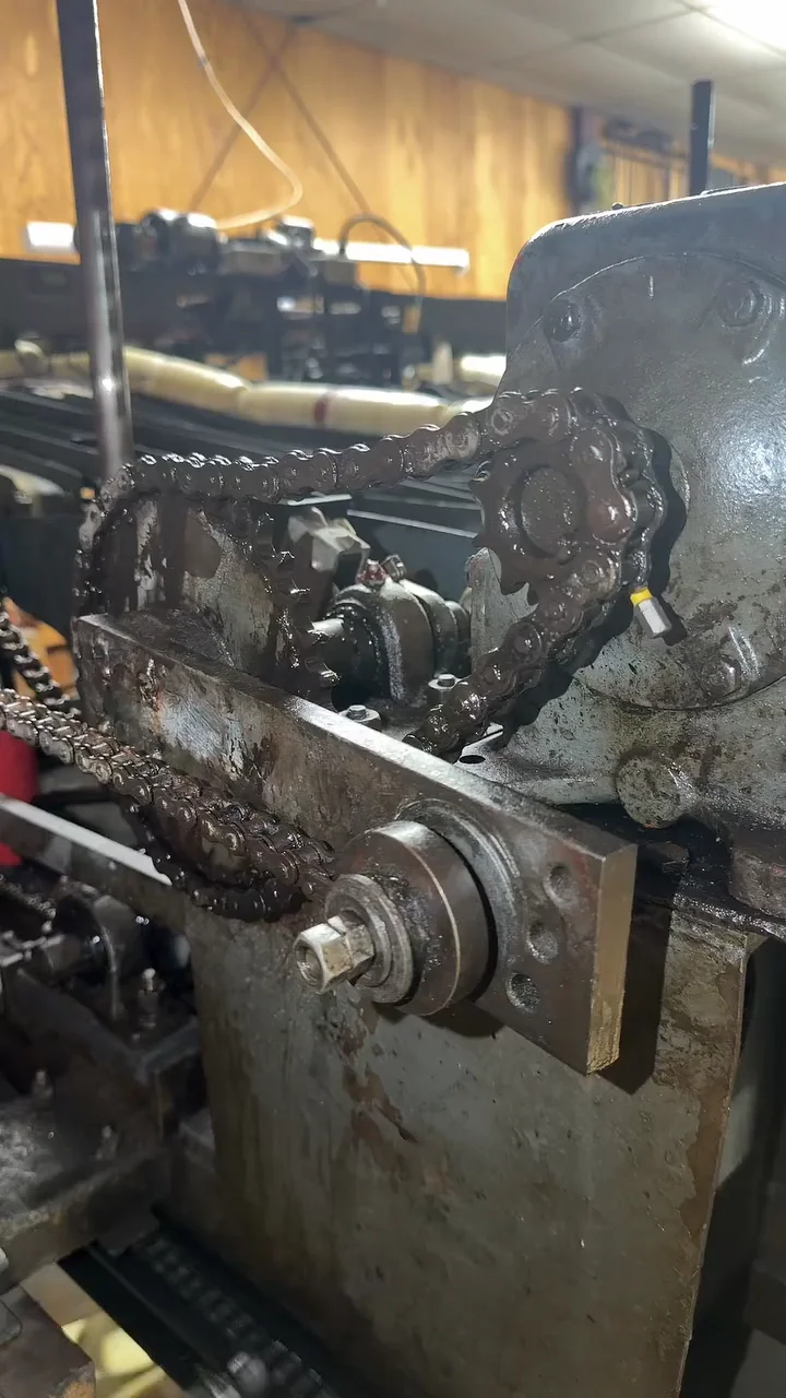 A pin-setting machine’s chain and sprocket, close up.